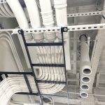 Proper design, and installation of white Cat 6 cabling in network room laid across a 7-foot network ladder rack that is installed so network cables can be neatly arranged and secured, preventing tangling, damage, or interference.